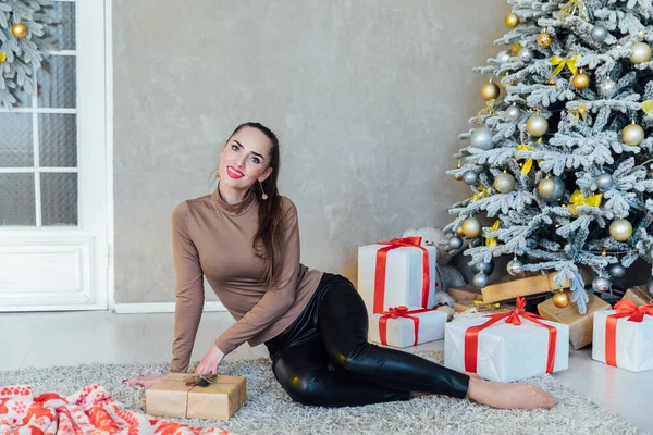 Piękna kobieta otwiera prezenty na choinkę na nowy rok — Zdjęcie stockowe