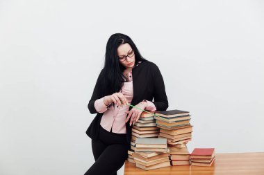 Masadaki bayan öğretmen, üniversitede okumak için kitaplarla birlikte.