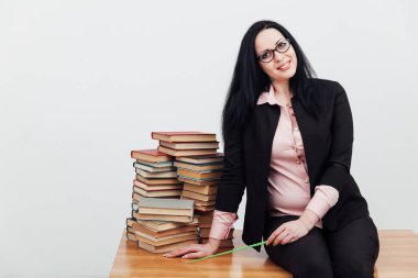 Masadaki bayan öğretmen, üniversitede okumak için kitaplarla birlikte.