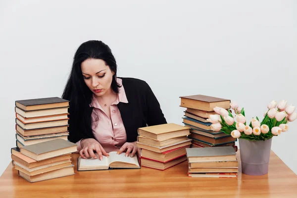 Женщина-преподаватель за столом с книгами для преподавания — стоковое фото