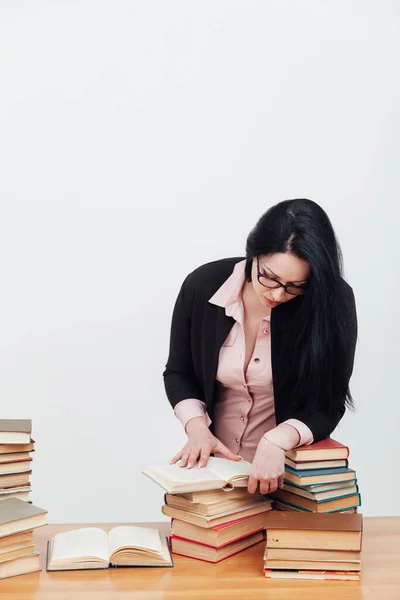 Женщина-преподаватель за столом с книгами для преподавания — стоковое фото