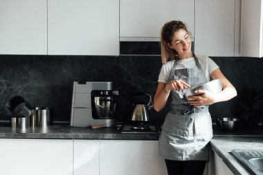 Kadın ev hanımı yemek pişirmek için tatlı kek hazırlıyor.