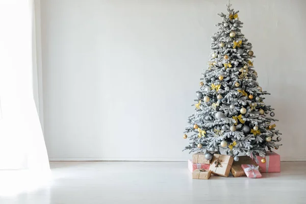Λευκό χιόνι καλύπτονται χριστουγεννιάτικο δέντρο με δώρα διακοσμήσεις το νέο έτος Εικόνα Αρχείου
