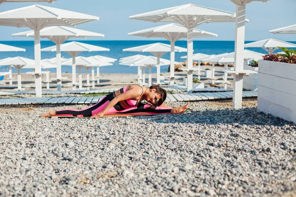 Piękna kobieta zaangażowana w fitness gimnastyka yoga asana na plaży nad morzem — Zdjęcie stockowe