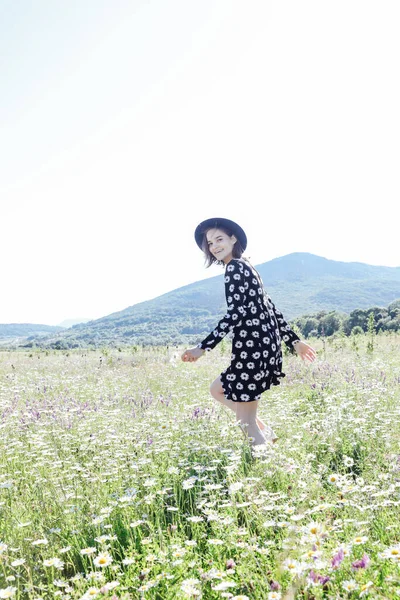 Güzel bir kadın papatya tarlasında yürüyor.