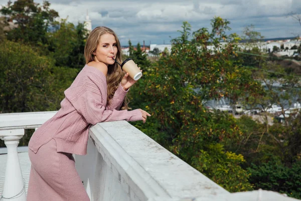 Güzel sarışın kadın sıcak kahve ya da çay içiyor.