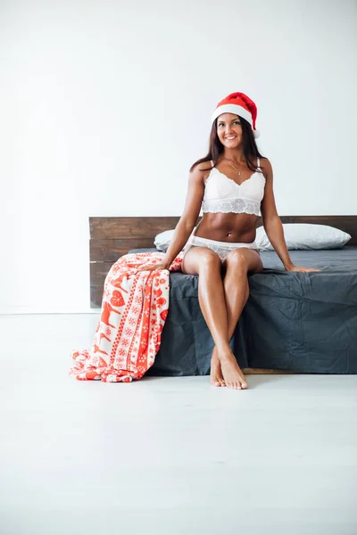 Kobieta w pościel na Boże Narodzenie w sypialni na łóżku Nowy rok — Zdjęcie stockowe
