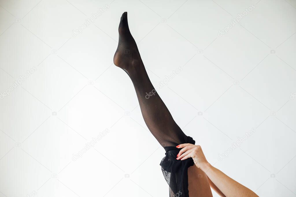 woman wears new tights on white background