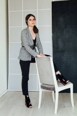 Ceketli ve kot pantolonlu güzel bir esmer kadının portresi.