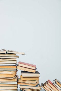 Kütüphanede beyaz arkaplanda öğrenmek için eski kitapların yığınları