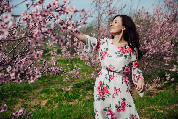 Çiçekli bir gül bahçesinde bahar elbisesi içinde güzel bir kadın.