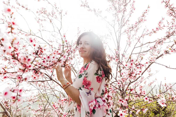 Çiçekli bir gül bahçesinde bahar elbisesi içinde güzel bir kadın. — Stok fotoğraf