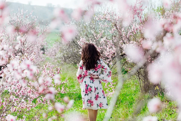 Piękna kobieta w wiosennej sukience w kwitnącym ogrodzie różanym — Zdjęcie stockowe