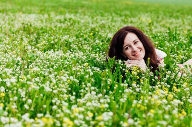 Çiçekli bahçede yeşil çimenli bahar elbisesi içinde güzel bir kadın.