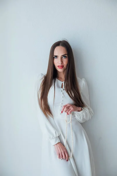 Retrato de una hermosa mujer en un vestido de luz blanca —  Fotos de Stock