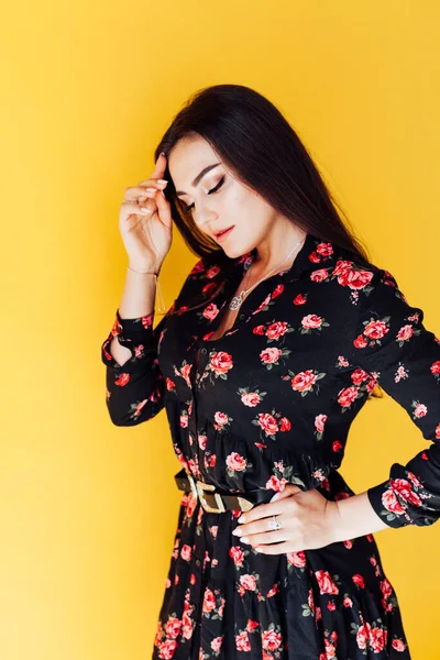 Mooie brunette vrouw in zwart jurk met bloemen — Stockfoto