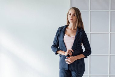 Ofiste takım elbiseli güzel sarışın bir kadın var.