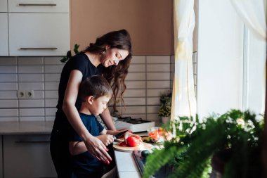 Anne ve oğul mutfakta sebze salatası hazırlayın.