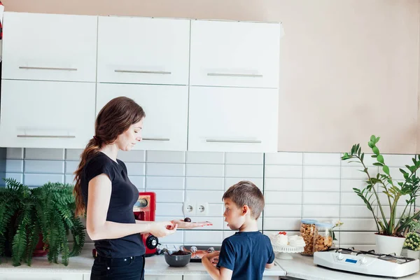 Mother and son prepare sweet desserts in the kitchen — Stock Photo, Image