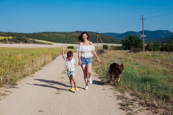 Mère et fils marchant avec le chien dans la nature — Photo