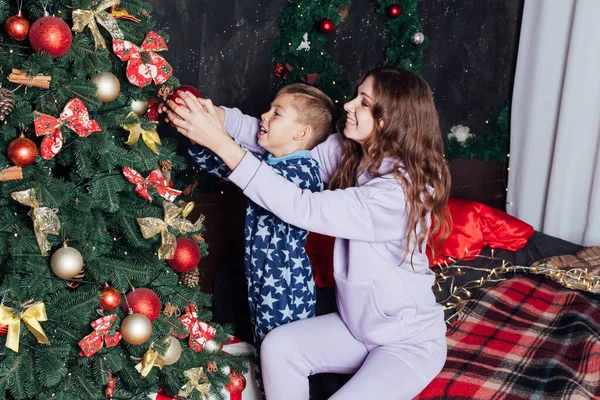 Мама и сын у елки с подарками Новый год — стоковое фото