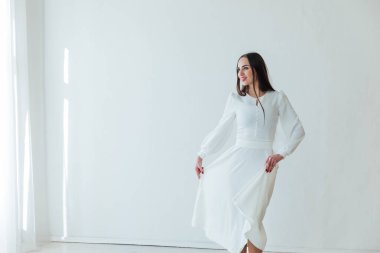 Beyaz arka planda açık yaz elbisesi içinde güzel bir kadın.