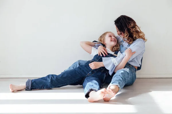 Moeder en dochter in jeans knuffel en glimlach — Stockfoto