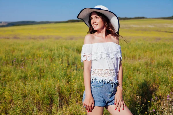 Porträtt av en vacker kvinna i en hatt med brädden i naturen — Stockfoto