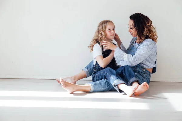 Madre e figlia in jeans abbracciano e sorridono — Foto Stock