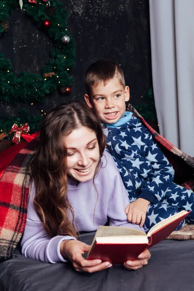 Мать и сын в спальне на кровати на Рождество — стоковое фото