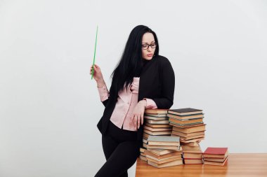 Öğrenim kitaplarıyla üniversite masasında kadın öğretmen.