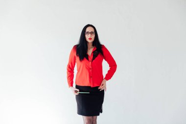 Beyaz bir ofiste iş kıyafetleri içinde güzel esmer bir kadın.