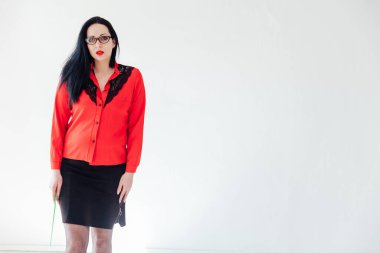 Beyaz bir ofiste iş kıyafetleri içinde güzel esmer bir kadın.