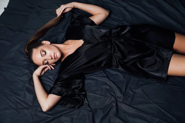 침실 침대에 검은 아마포를 입은 아름다운 여인의 사진 — 스톡 사진