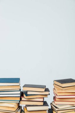 Kütüphanede beyaz arkaplanda öğrenmek için eski kitapların yığınları