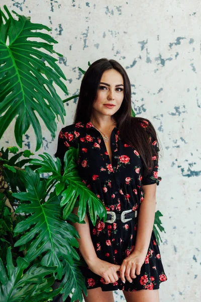 Hermosa mujer morena en vestido negro con flores — Foto de Stock