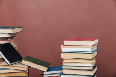Üniversite kütüphanesinde kahverengi arkaplan bilgisi öğretmek için kitap yığınları