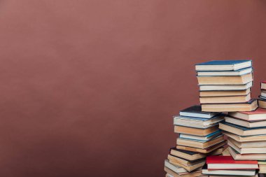 Bilgi üniversitesi kütüphanesinin kahverengi arka planını öğretmek için kitap yığınları