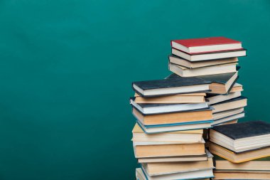 Üniversite kütüphanesi hakkında bilgi vermek için kitap yığınları yeşil arkaplan