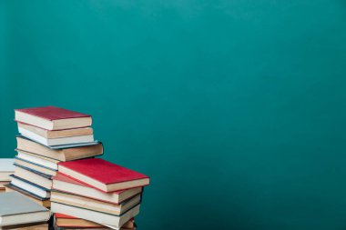 Üniversite kütüphanesi hakkında bilgi vermek için kitap yığınları yeşil arkaplan