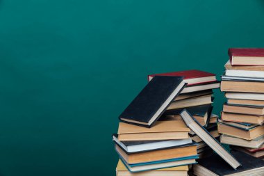 Üniversite kütüphanesi hakkında bilgi vermek için kitap yığınları yeşil arkaplan