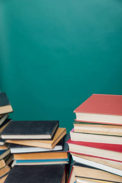 Pile di libri per l'insegnamento conoscenza della biblioteca universitaria sfondo verde — Foto Stock