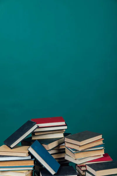 Pile di libri per l'insegnamento conoscenza della biblioteca universitaria sfondo verde — Foto Stock