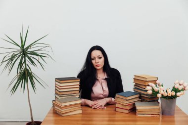 Masasındaki güzel esmer kadın. Öğrenmek için kitapları var.