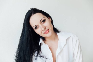 Beyaz gömlekli, şık, esmer bir kadının portresi.