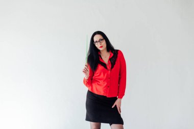 Beyaz bir ofiste iş kıyafetleri içinde güzel esmer bir kadın.