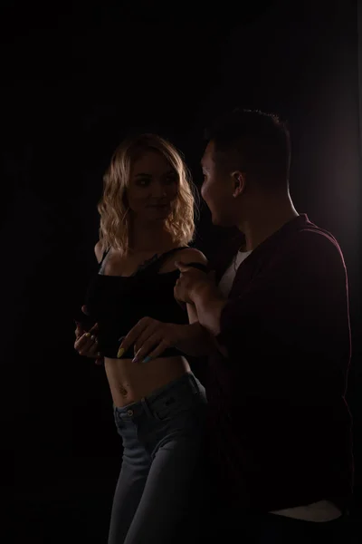 Женщина и мужчина танцуют под музыку в темноте — стоковое фото