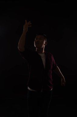 Adam karanlıkta tek başına müzikle dans ediyor.