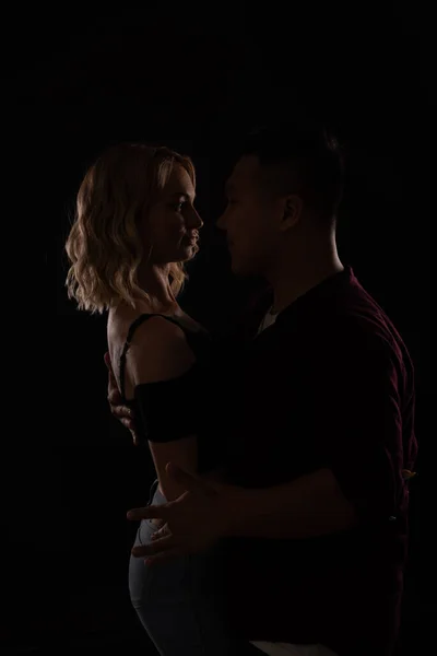 Женщина и мужчина танцуют под музыку в темноте — стоковое фото
