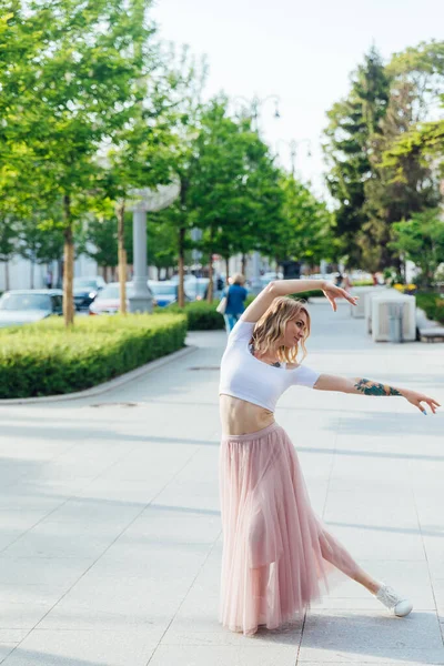 Güzel bir kadın şehrin sokaklarında müzik eşliğinde dans ediyor. — Stok fotoğraf